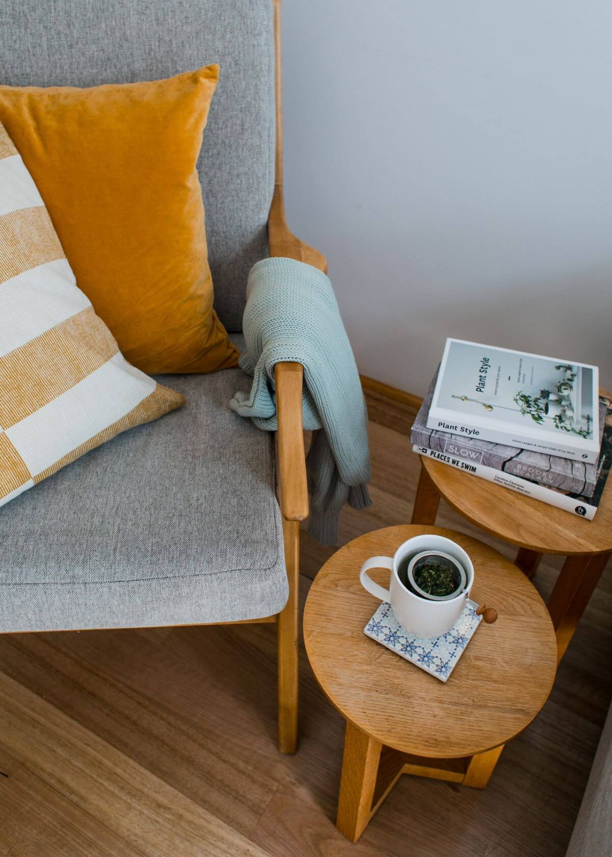 Sillón acompañado de mesa ratona con libros y una infusión